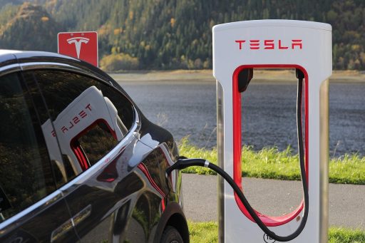 Elektrische wagen die oplaadt aan een thuislaadpaal bij een Belgische woning