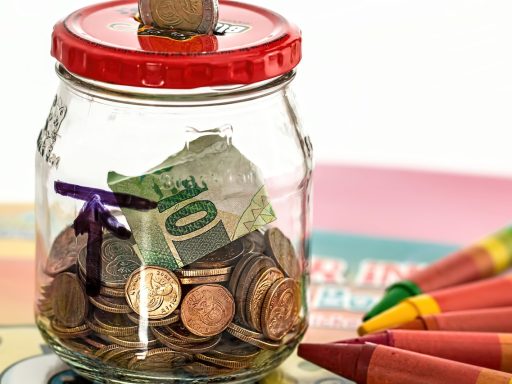 Zelfstandige in bijberoep die zijn financiën beheert aan een bureau met notitieboek en spaarpot