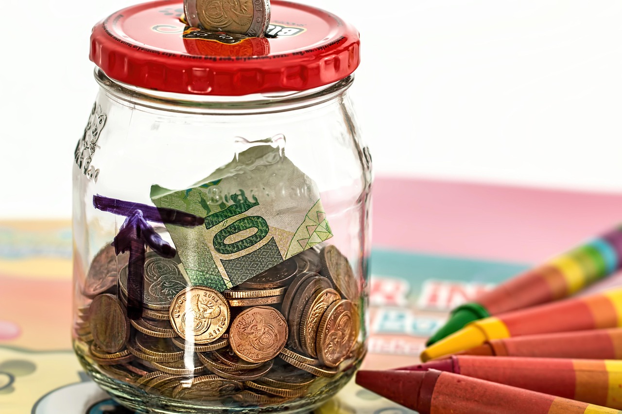 Zelfstandige in bijberoep die zijn financiën beheert aan een bureau met notitieboek en spaarpot