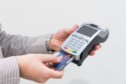Persoon die maandelijkse bankafschriften doorneemt om overbodige abonnementen op te zeggen