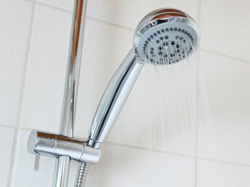 Iemand die de watermeter afleest in een Belgische woning om het waterverbruik te controleren