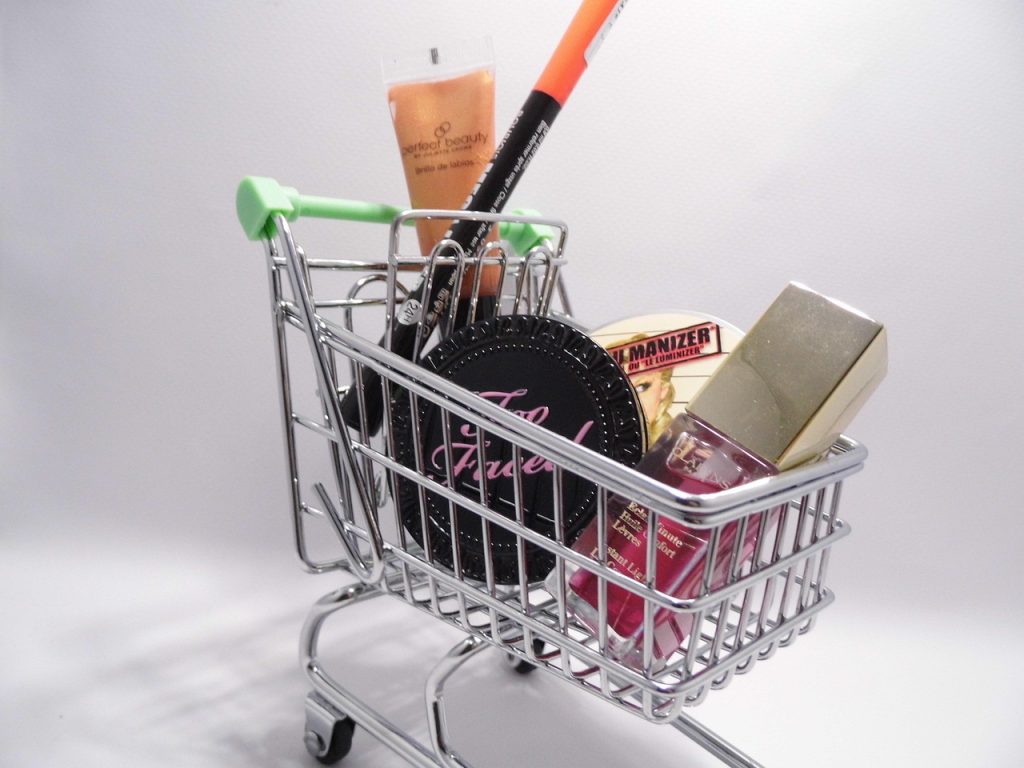 Herbruikbare boodschappentassen en een boodschappen wagen naast elkaar op een stoep