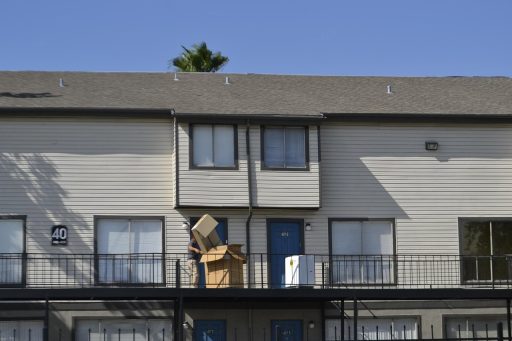 Jongere die voor het eerst alleen gaat wonen en dozen uitpakt in een nieuw appartement