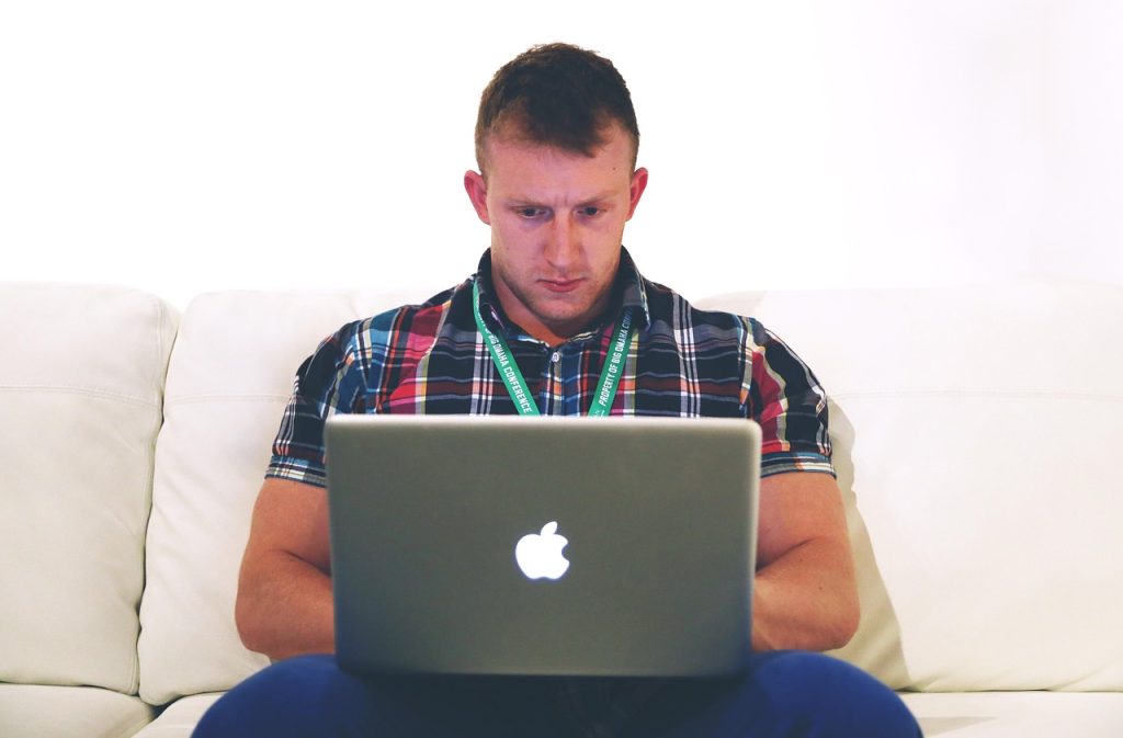 Zelfstandige werkt aan laptop thuis en beheert zijn financiën via MyMinfin