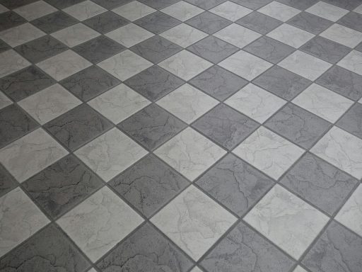 Hand die een tapijttegel legt op een kale vloer naast bestaande tapijttegels