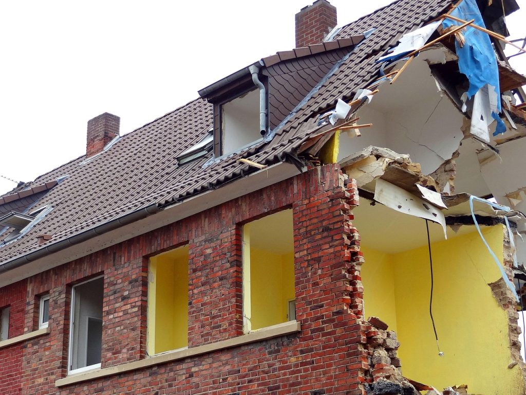 Vakman boort gat in buitengevel voor inblaasisolatie van spouwmuur