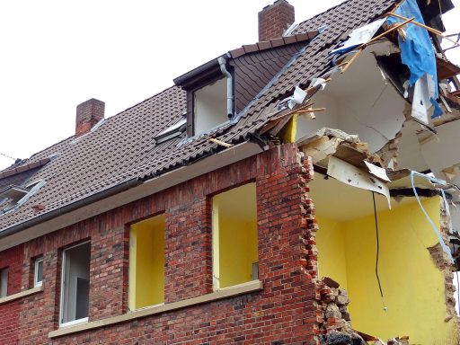 Vakman boort gat in buitengevel voor inblaasisolatie van spouwmuur
