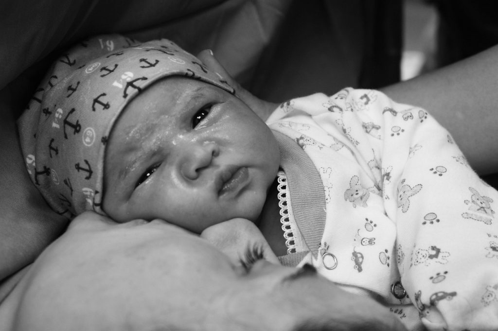 Pasgeboren baby in een ziekenhuiskamer met de moeder