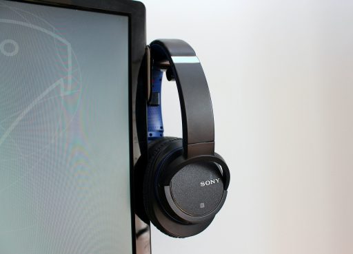 Een studiokoptelefoon en externe DAC op een houten bureau, klaar voor een serieuze luistersessie